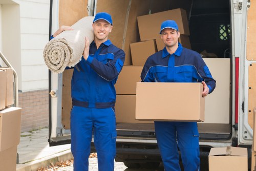 Careful loading of a sofa and dining furniture into a moving vehicle
