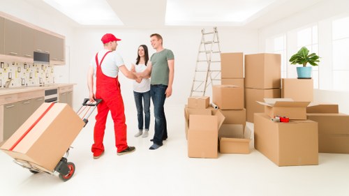 Local movers carrying boxes through a Stockwell apartment building