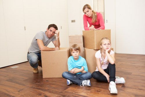 Movers carrying furniture through a Stockwell property staircase