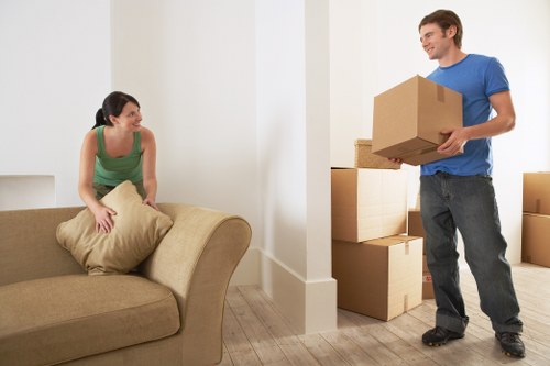 Movers carrying furniture through a Stockwell flat staircase